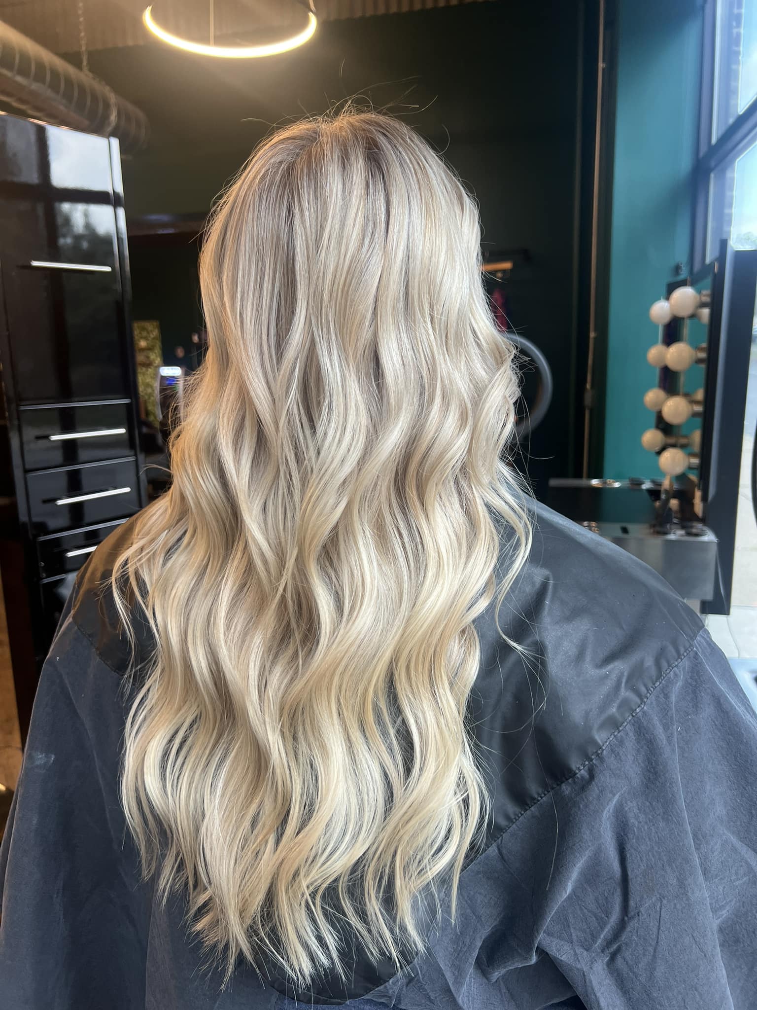 Long silver-blonde waves styled at Hair Mafia Salon
